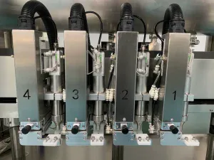 Close-up details of the liquid filling machine's filling head